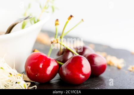 Dettaglio di ciliegie rosse su tagliere di ardesia Foto Stock