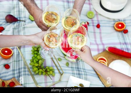 Persone tostare gli occhiali da vino al picnic Foto Stock