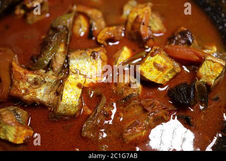 Meen Vatichathu o Pattichathu, pesce sardino cotto. Curry tradizionale di pesce caldo e piccante Kerala India con foglie di curry rosso e verde. Foto Stock