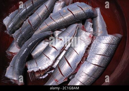 Sardine fresche tagliate testa ed essendo preparati per cucinare il kerala indiano del sud sugo e friggere fatti in casa Foto Stock