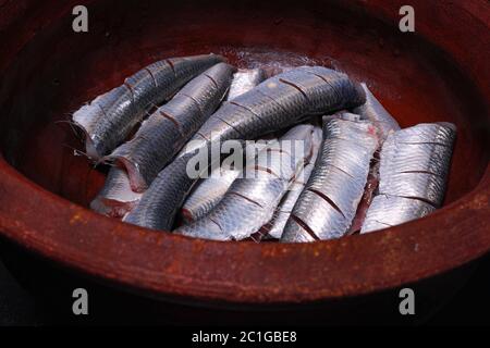 Sardine fresche tagliate testa ed essendo preparati per cucinare il kerala indiano del sud sugo e friggere fatti in casa Foto Stock