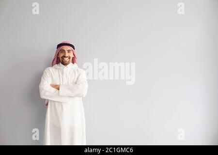 Uomo d'affari arabo sorridente ritratto su uno sfondo grigio Foto Stock