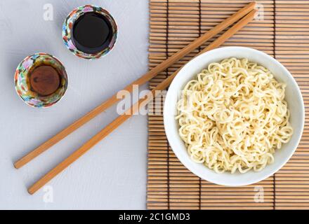 Tagliatelle semplici in recipiente con bastoncini - foto in alto Foto Stock