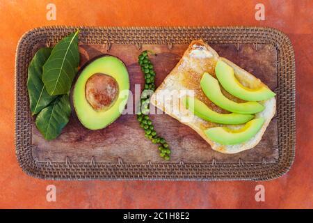 Avocado affettato su pane con pepe verde fresco Foto Stock