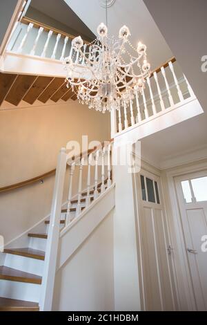 Bella scalinata in stile vittoriano con lampadario in cristallo e ringhiera decorativa Foto Stock