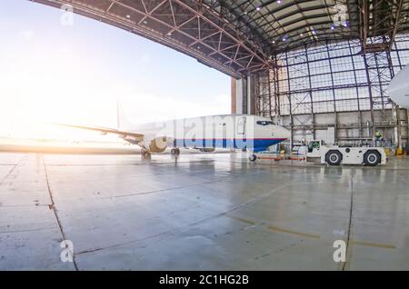 Dopo la riparazione, estrarre l'aereo dall'hangar con un trattore Foto Stock