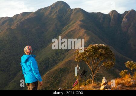 Persone non riconosciute che godono della vista del paesaggio montano da una montagna Foto Stock