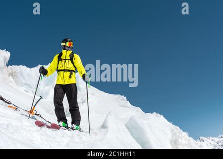 Un freerider sciatore in completo vestito si trova su un ghiacciaio nel Caucaso settentrionale Foto Stock