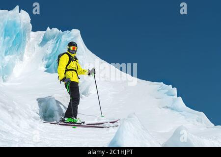 Un freerider sciatore in completo vestito si trova su un ghiacciaio nel Caucaso settentrionale Foto Stock