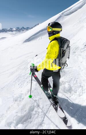 Un freerider sciatore in completo vestito si trova su un ghiacciaio nel Caucaso settentrionale sullo sfondo del caucasico neve-capp Foto Stock