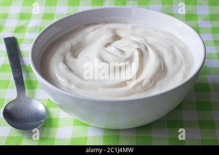 Naturale bianco normale yogurt greco in ciotola closeup - sfondo di yogurt Foto Stock