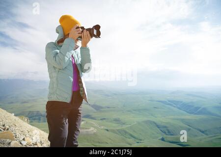 Ritratto di un fotografo professionista all'aperto. Una fotografa di ragazza scatta foto della sua fotocamera sulla sua fotocamera. Trevor Foto Stock