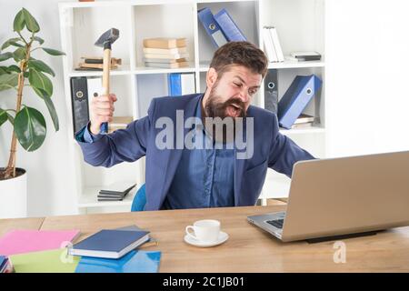 Distruggi il notebook. Lavoro odioso. Computer difettoso. Responsabile MAD. Utente infastidito. Connessione Internet lenta. Software obsoleto. Ritardo del computer. Sistema di ritardo. Odiare la routine dell'ufficio. Uomo sopportato schiacciare il computer. Foto Stock