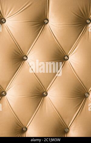 Fondo tessile beige morbido con bottoni simmetrici sugli angoli dei diamanti. Elementi di arredamento morbidi e costosi. Lusso Foto Stock