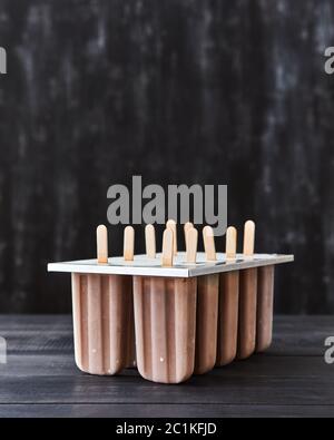 Caffè naturale per lecca-lecca di ghiaccio in forma di plastica su un di legno nero con sfondo spazio copia. Foto Stock