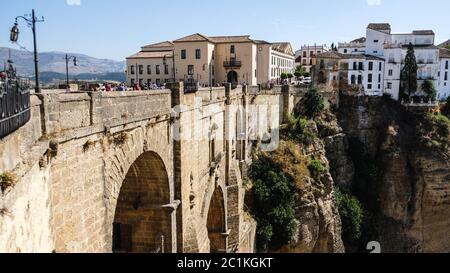 Puente Nuevo famoso nuovo ponte nel cuore del vecchio villaggio Ronda in Andalusia, Spagna. Punto di riferimento turistico in una giornata di sole con edifici sul retro Foto Stock