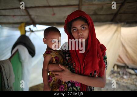 Una madre Rohingya con il suo bambino si trova di fronte ad un campo di fortuna nel campo profughi di Kutupalong, Bangladesh, martedì 03 ottobre 2017. Foto Stock