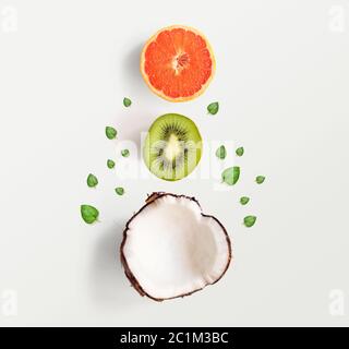 Layout creativo fatto di noci di cocco e foglie. Disposizione piatta. Concetto di cibo. Cocco su sfondo rosa. Foto Stock