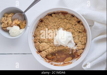 Apple Crumble dessert con gelato alla vaniglia su sfondo bianco - vista superiore foto Foto Stock