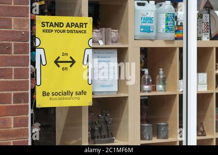 Eastleigh, Hampshire, Regno Unito. 15 Giugno 2020 . Negozi che mostrano linee guida di divaricamento sociale in finestre come centri commerciali e non essenziali al dettaglio aprire per la prima volta dal 23 marzo 2020, quando il governo britannico ha implementato il coronavirus lockdown Eastleigh, Hampshire, UK Credit: Dawn Fletcher-Park/Alamy Live News Foto Stock