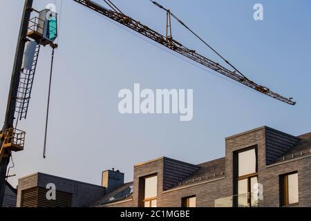 costruzione industriale primo piano di una gru contro il cielo blu sullo sfondo - cantiere progresso architettura sviluppo Foto Stock