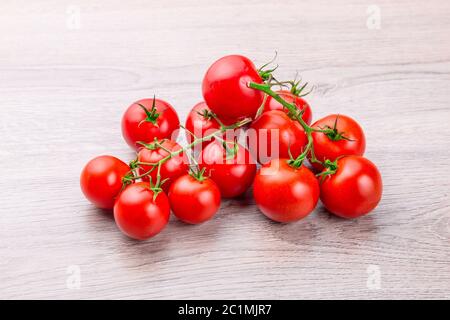 Freschi pomodori ciliegia sulla rustico sfondo di legno Foto Stock