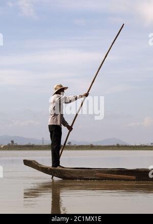 Dak Lak, VIETNAM - Gennaio 6, 2015 - Uomo spingendo una barca con un polo Foto Stock