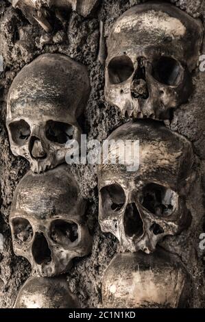 Teschi umani e ossa a un muro nella cappella delle ossa Evora Foto Stock