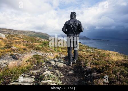 Escursionista passeggiate in montagna in un giorno di pioggia, obiettivo successo e la libertà. Travling Norvegia paesaggio Foto Stock