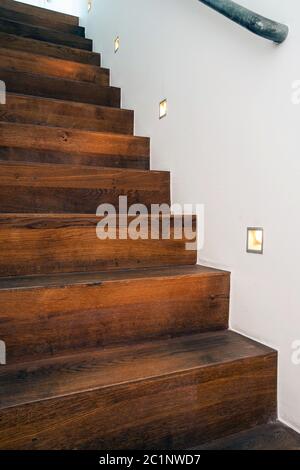 Scale di legno di notte con luce a led nel muro bianco design moderno Foto Stock