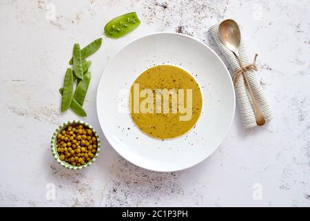 Zuppa cremosa con pisello verde in una ceramica piastra bianca Foto Stock