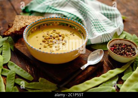 Pisello verde minestra di crema nella ciotola grigio Foto Stock