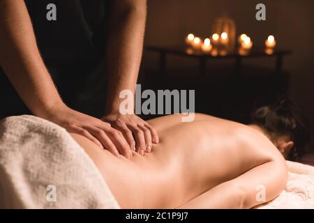 Primo piano delle mani maschili. Massaggiatore fa massaggio per la vita di una ragazza giovane. Riabilitazione, terapia di bellezza medicina Foto Stock