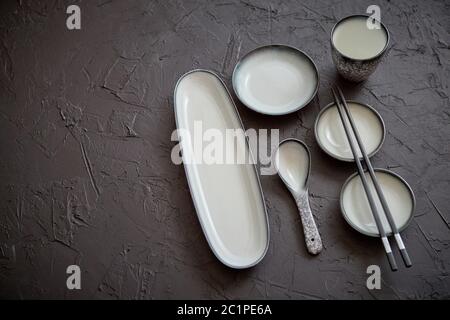 Set di vuoto piatti in ceramica per il sushi e rotola su una pietra nera tabella Foto Stock