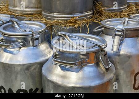 Lattine di latte tradizionali di fronte ad una fattoria Foto Stock