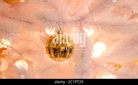 Oro sullo sfondo di Natale di de-focalizzato con luci decorate albero Foto Stock