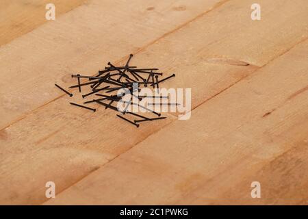 Chiodi di acciaio su un pavimento di legno Foto Stock