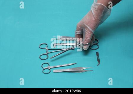 La mano dei medici sta tenendo un paio di forbici Foto Stock