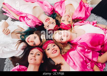 Ritratto di belle ragazze in rosa accappatoi celebrando doccia nuziale. Foto Stock
