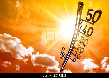 Caldo estate o sfondo caldo onda, sole incandescente su cielo drammatico con termometro Foto Stock