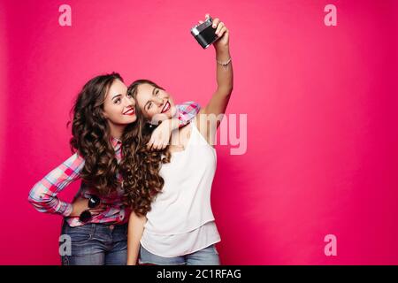 Due belle donne che scattano ritratti da soli con la fotocamera. Foto Stock