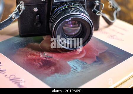 Fotocamera retrò, film e album fotografico vecchio sul tavolo Foto Stock