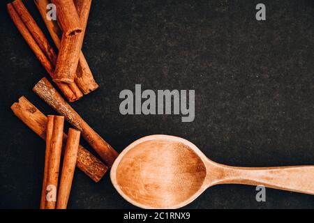 cucchiaio di legno con anice stellato, bastoncini di cannella, coni, spezie di natale sfondo Foto Stock