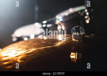 Primo piano tamburo in una stanza buia contro lo sfondo del riflettore. Sfondo atmosferico simbolo di musica rock o jazz dr Foto Stock