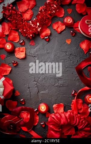 Petali di rose rosse, candele, accessori di datazione, regali in scatola, cuori, paillettes Foto Stock