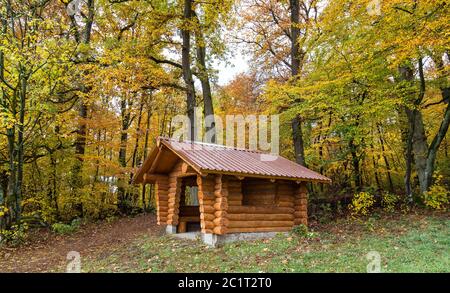 Capanna di legno fatta di tronchi d'albero al bordo della foresta. Foto Stock