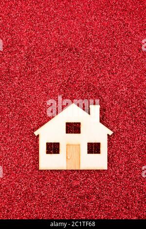 Casa in legno forma sul rosso sfondo glitter Foto Stock