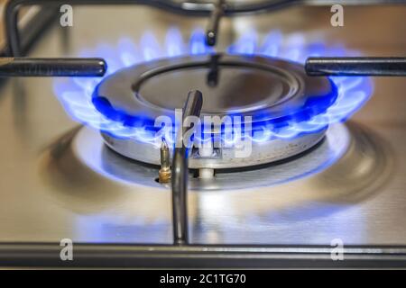 Vista ravvicinata di un fornello da cucina con fiamma blu Foto Stock