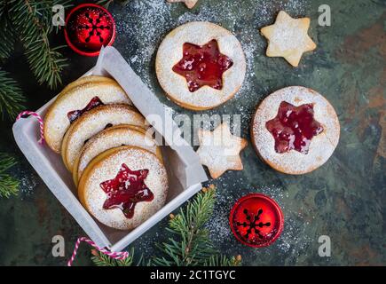 Biscotti di Natale. Biscotti Linzer con marmellata di lamponi su sfondo verde. Biscotti austriaci tradizionali ripieni. Vista dall'alto e spazio per la copia Foto Stock