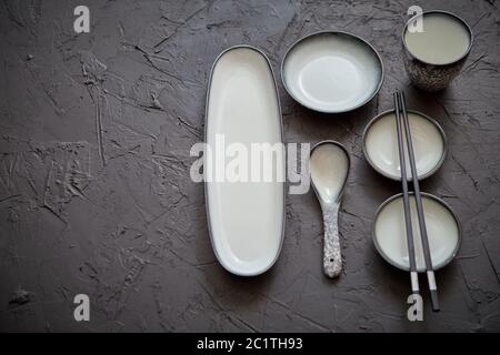 Set di vuoto piatti in ceramica per il sushi e rotola su una pietra nera tabella Foto Stock